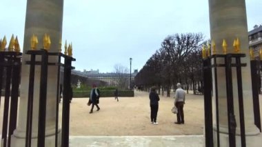 PARIS, FRANCE - DECEMBER, 2022: View of Gardens of the Palais-Royal in city downtown. Walking people, cloudy weather