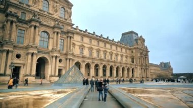 PARIS, FRANCE - 2022: Napolyon Avlusu 'ndan Louvre Müzesi. Louvre Sarayı, bir sürü turist, bulutlu hava