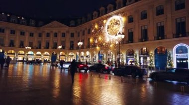 PARIS, FRANCE - 2022 ARALIK: gece şehir merkezindeki Vendome Place manzarası. Yürüyen insanlar, klasik binalardaki dükkanlar, Noel süslemeleri.