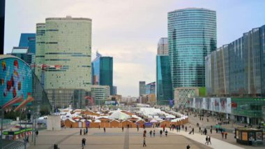 PARIS, FRANCE - DECEMBER, 2022: View of the Christmas fair in business centre, modern buildings, walking people