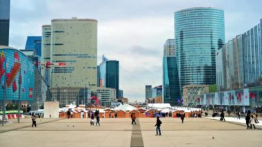 PARIS, FRANCE - DECEMBER, 2022: View of the Christmas fair in business centre, modern buildings, walking people