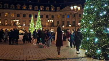 PARIS, FRANCE - DECEMBER, 2022: View of a couple dancing at the Vendome Place in city downtown. Christmas decorations