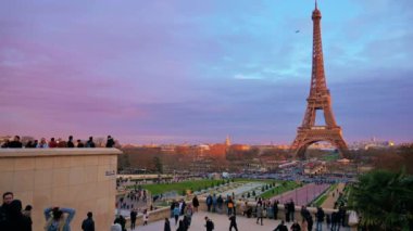 PARIS, FRANCE - DECEMBER, 2022: View of the Eiffel Tower from the Trocadero Square with multiple people at sunset. Gardens of the Trocadero with people, cityscape