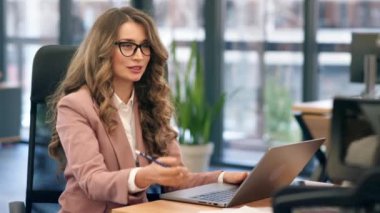 Female team leader discussing business affairs with employees. Laptop on the table
