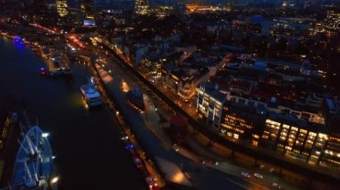 Hamburg 'un hava aracı görüntüsü, Almanya. Elbe kıyı şeridi, demirli tekneler, liman, klasik ve modern binalar, arabalı yollar ve gece lambaları.