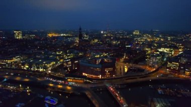 Hamburg 'un hava aracı görüntüsü, Almanya. Elbe kıyı şeridi, demirli tekneler, liman, klasik ve modern binalar, arabalı yollar ve gece lambaları.