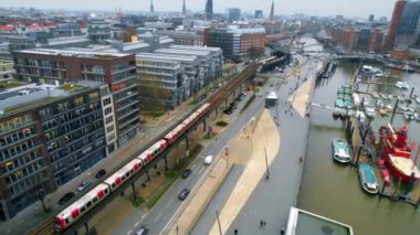 HAMBURG, GERMANY - JANUARY, 2023: Aerial drone view of Hamburg, Germany. Elbe coastline, moored boats, sea port, classic and modern buildings, roads with cars and trains. Cloudy weather