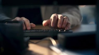 Close view of a worker typing on a keyboard in an office