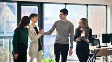 Men and women workers communicating in an office, panoramic windows on the background