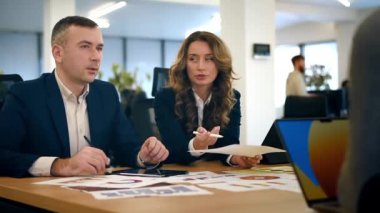 Business meeting in an office, workers discussing business affairs using charts