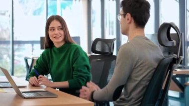 Team leader discussing business affairs with a female worker. Business meeting at the office. Papers and tablet on the table
