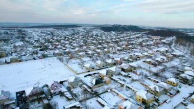Moldova 'daki bir köyün kışın hava aracı görüntüsü. Yerleşim yerleri, yollar ve tarlalar karla kaplı, çıplak ağaçlar