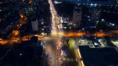 Aerial drone timelapse view of Chisinau at night, Moldova. View of the city with multiple buildings, roads with moving cars, park with lake, illumination