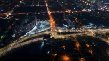 Aerial drone timelapse view of Chisinau at night, Moldova. View of the city with multiple buildings, intersection with moving cars, illumination