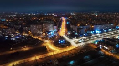 Aerial drone timelapse view of Chisinau at night, Moldova. View of the city with multiple buildings, roundabout with moving cars, illumination