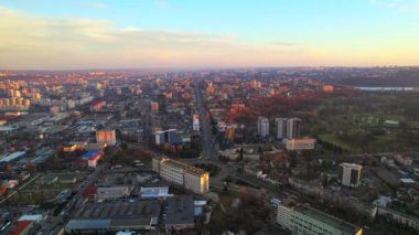 Chisinau 'nun günbatımında Moldova' da hava aracı görüntüsü. Şehrin birçok binası, arabalı yolları ve parkı var.