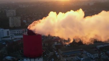 Aerial drone view of thermal power plant in Chisinau at sunset, Moldova. View of a pipe with felling steam, cityscape on the background