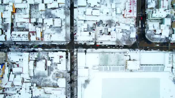 冬にチシナウの空中ドローン垂直ビュー モルドバ 雪に覆われた複数の建物や道路で街の景色 移動車 — ストック動画