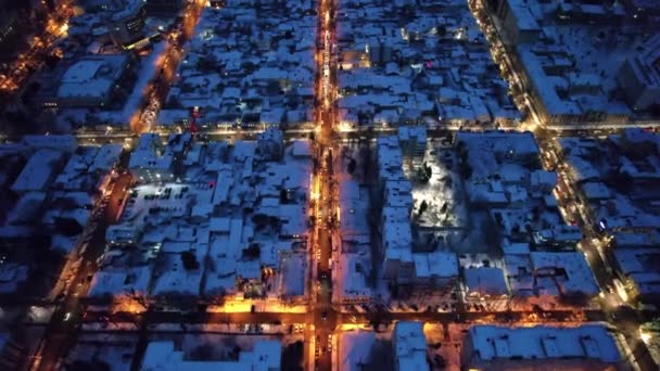 冬の日没でチシナウの空中ドローンビュー モルドバ 移動車 照明で覆われた複数の建物や道路で街の景色 — ストック動画