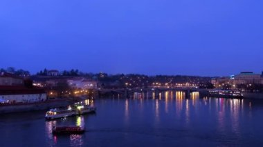 Vltava River and city with buildings, boats on river, Czech Republic