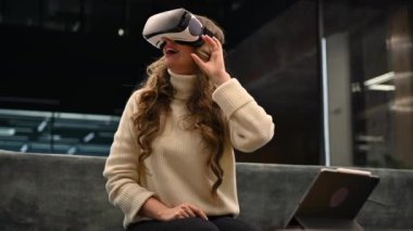 Happy woman working with VR virtual reality set on head at the office
