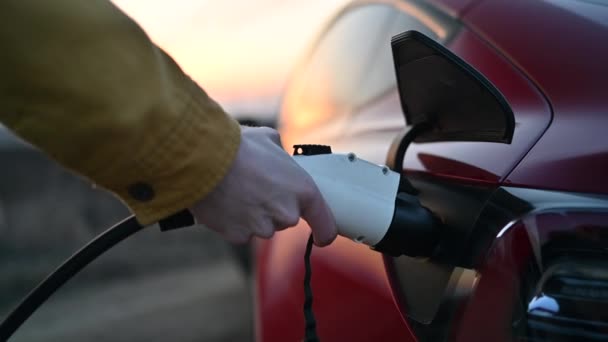 Man Charging Red Electric Car Sunset — Stok video