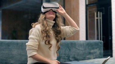 Sarışın, beyaz bir kadın VR gözlük takıyor ve ofiste sanal gerçekliği keşfetmeye başlıyor.