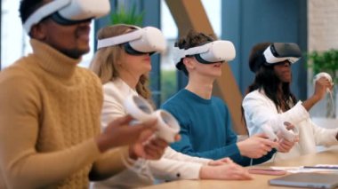 VR 'da bir ofiste iş konferansı. Çok ırklı bir grup insan. Genç bir adam masadaki VR gözlüklerini, kumandayı, kağıtları ve aletleri kullanmayı öğretiyor.