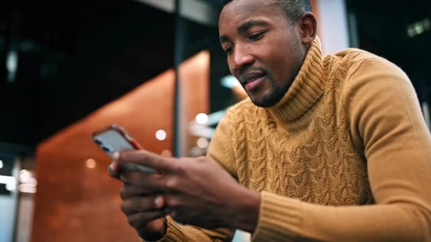 Hombre Negro Está Usando Teléfono Inteligente Mientras Está Sentado Una — Vídeos de Stock