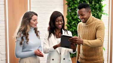 Ofisteki çok ırklı işçiler tablet kullanarak iş konuşuyorlar. Yavaş çekim