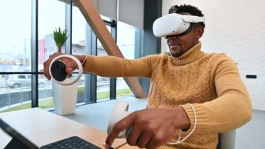 Sanal gerçekliği, sanal gerçeklik gözlüğü ve kumanda kullanarak keşfeden siyah bir adam. Yavaş çekim