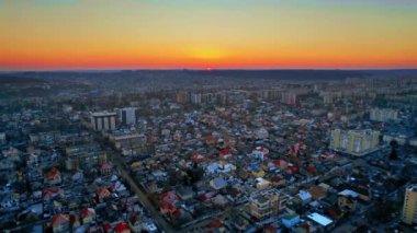 Chisinau 'nun günbatımında Moldova' da hava aracı görüntüsü. Birden fazla konut binası olan ve güneşin üzerinde batan şehir manzarası