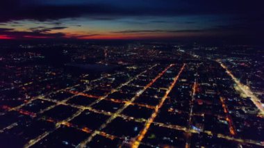 Chisinau 'nun günbatımında Moldova' da hava aracı görüntüsü. Şehir manzarası, birden fazla bina, göl kenarında park, aydınlık yollar.