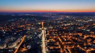 Chisinau 'nun gün batımında Moldova' daki hava aracı görüntüsü. Birden fazla konut binası olan şehir manzarası, hareket eden arabalı yollar, aydınlatma