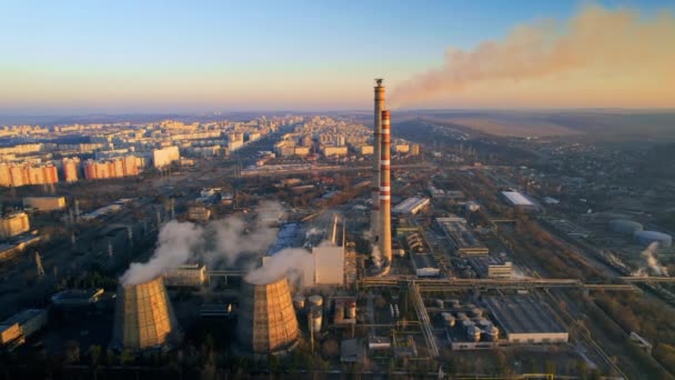 モルドバ日の出時チシナウの火力発電所の空中ドローンビュー 蒸気を感じるパイプの眺め 周りのインフラ 背景の街並 — ストック動画
