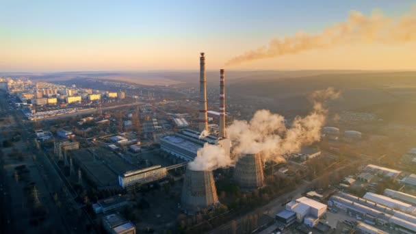 モルドバ日の出時チシナウの火力発電所の空中ドローンビュー 蒸気を感じるパイプの眺め 周りのインフラ 背景の街並 — ストック動画