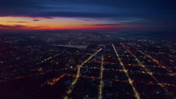 日没でチシナウの空中ドローンビュー モルドバ 複数の建物がある街の景色 湖のある公園 照明付きの道路 — ストック動画