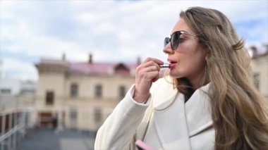 Sokakta kırmızı ruj süren kadın, ağır çekimde.