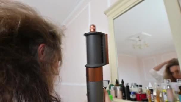 窓の近くの家でヘアドライヤーを使う女性 — ストック動画