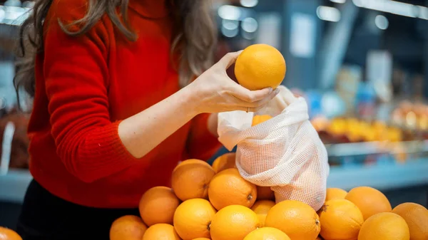Een Vrouw Die Sinaasappels Plukt Een Herbruikbare Zak Een Winkel — Stockfoto