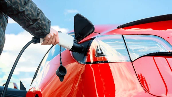 Vista Perto Uma Mulher Carregador Plugging Seu Carro Vermelho Elétrico — Fotografia de Stock