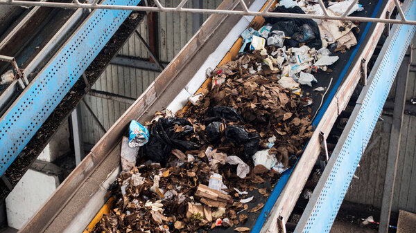 Garbage moving on a conveyor belt at waste sorting plant