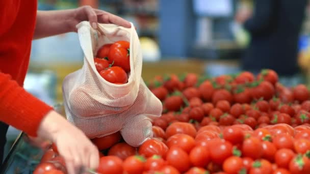 女人在商店里的一个可重复使用的袋子里捡西红柿 生态与地球日 — 图库视频影像