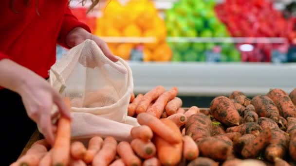 Mujer Recogiendo Zanahorias Una Bolsa Reutilizable Una Tienda Ecología Temática — Vídeos de Stock