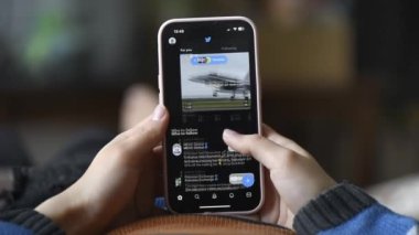 CHISINAU, MOLDOVA - Mart 2023: Bir kişi akıllı telefonuyla Twitter 'ı açıyor ve yayını kaydırmaya başlıyor