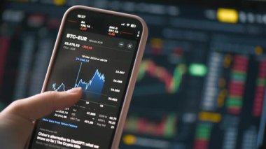 CHISINAU, MOLDOVA - Mart 2023: Akıllı telefonunda bitcoin döviz kuruna sahip bir uygulama kullanan bir kişi