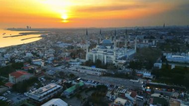 Türkiye 'de gün batımında İstanbul' un hava aracı görüntüsü. Etrafında bahçeler ve binalar olan Mavi Cami Boğazı 'nda gemiler var.