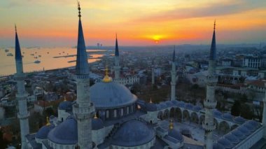 Türkiye 'de gün batımında İstanbul' un hava aracı görüntüsü. Etrafında bahçeler ve binalar olan Mavi Cami Boğazı 'nda gemiler var.