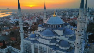 Türkiye 'de gün batımında İstanbul' un hava aracı görüntüsü. Etrafında bahçeler ve binalar olan Mavi Cami Boğazı 'nda gemiler var.