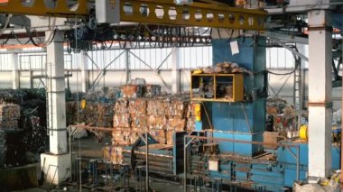 Atık ayıklama tesisinin iç görüntüsü. Sıkıştırılmış çöp küpleri, özel araçlar